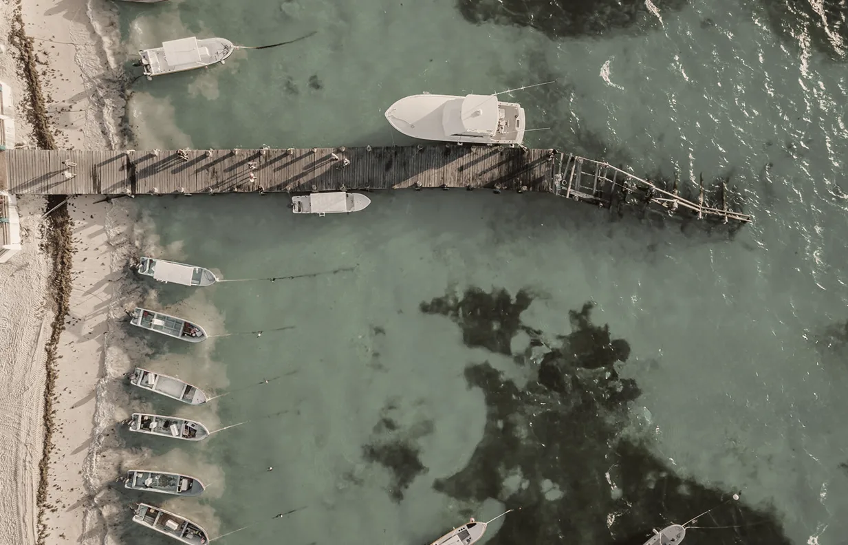 Vista cenital del muelle de Puerto Morelos y sus lanchas sobre el arrecife